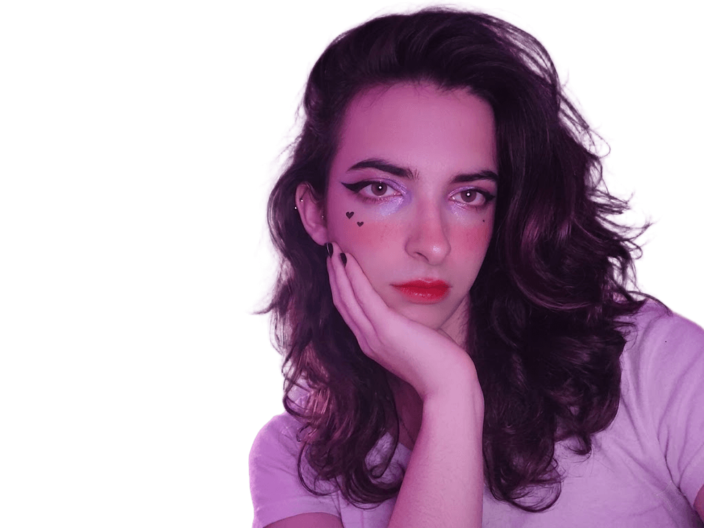 Deliana, glitter eyeshadow, heart drawn under the right eye, hand under chin, looking at camera